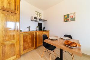 a kitchen with a table with a plate of bread at Studio Ô Calm - Confort & sérénité, proche aéroport in Saint-Denis