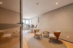 a waiting room with chairs and tables in a building at Roomo Transamerica SP Vila Clementino in Sao Paulo +30 photos