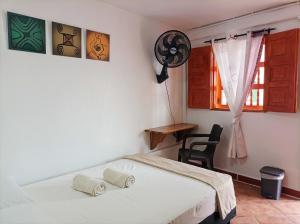 a bedroom with a bed and a chair and a window at Petroglifo Room Támesis in Támesis