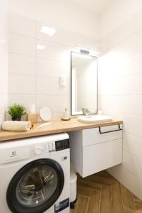 a bathroom with a washing machine and a sink at Lonyay Downtown Apartment by FirstHost in Budapest