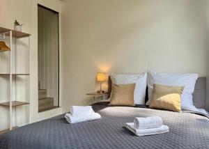 a bedroom with a bed with two towels on it at TT Living Apartments BONITAS & DIVINITAS I 2 Schlafzimmer I Küche I Vollbad I Waschmaschine in Rellingen