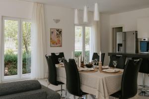 a dining room with a table and chairs at Villa Melograno by Domus Mirus - Rooftop Cinema, Pool, 6-Minute Walk to Beach in Splitska