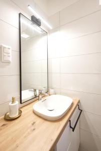 a bathroom with a white sink and a mirror at Lonyay Downtown Apartment by FirstHost in Budapest +27 photos