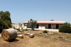 a building with a large bale of hay and benches at Tenuta Petra Chiara in Torre Lapillo