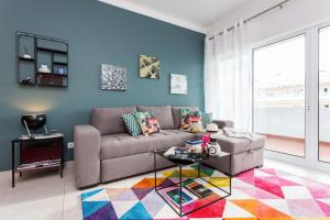 a living room with a couch and a colorful rug at Tuga Penthouse in Portimão
