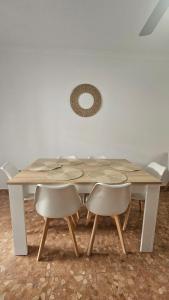una mesa de madera con 2 sillas y un espejo en Camaron Beach House By Sanlúcar Housing, en Chipiona