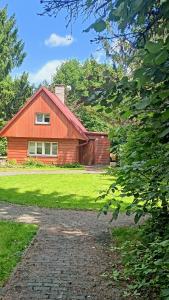 a red barn with a brick driveway in front of it at Srubová chata Oaza 1 in Trojanovice