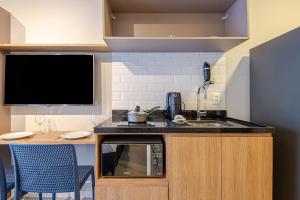 a small kitchen with a sink and a tv at Roomo Transamerica SP Vila Clementino in Sao Paulo