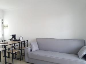 a living room with a couch and a table at TUNERAS SUNSET Puerto Rico Apartment, Sea view, Pool, Perfect for sun lovers in Mogán