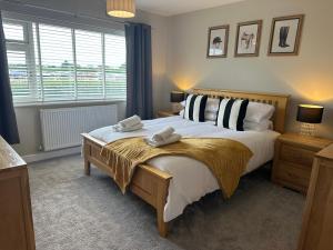 a bedroom with a large bed with two towels on it at Modern homely well equipped 2BR bungalow next to the racecourse free parking in Hereford