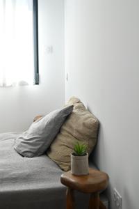una camera da letto con un letto con una pianta in vaso su uno sgabello di Modern and bright vacation home a Bormes-les-Mimosas
