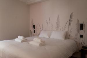 a bedroom with a white bed with towels on it at Logis Hotel de l'Artuby in Séranon
