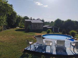 a group of chairs sitting around a swimming pool at House&mini-Camp SKELICA in Neštin