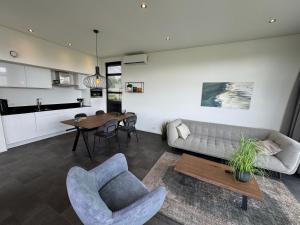 a living room with a couch and a table at Enkhuizer Strand Chalet Meeresruhe Haus Nr 207 in Enkhuizen
