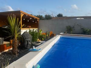 a swimming pool with a statue of a head next to it at Chambre chez l habitant Cissac-Medoc in Cissac-Médoc