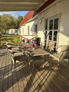 a wooden deck with tables and chairs on a house at Burning Bridge Motell & Vandrarhem in Götene