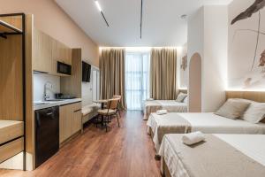 ドゥラスにあるKingdom Family Apartment's Durres Centerのベッド2台とキッチン付きのホテルの部屋