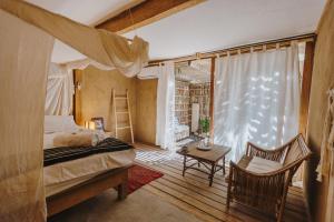 a bedroom with a bed and a chair and a window at Eco Lodge Mancora in Máncora +100 photos