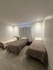 a room with two beds and a window at Ribera de Cafayate in Cafayate
