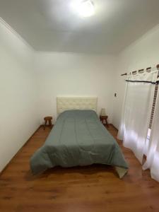 a bedroom with a bed in a white room at Casa Quinta Abuelo Gordo in San Pedro