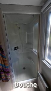 a shower with a glass door in a bathroom at Mobil home confort in Hyères