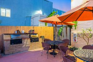 an outdoor patio with a grill and tables and umbrellas at 2 bed 2 bath penthouse condo with AC and Ocean Views in San Diego