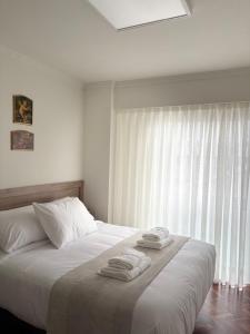 a bedroom with a bed with two towels on it at Cardenal Centro in Monforte de Lemos