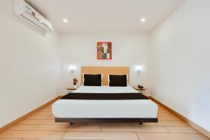 una camera da letto con un letto in una stanza bianca di Super Townhouse Visakhapatnam a Visakhapatnam