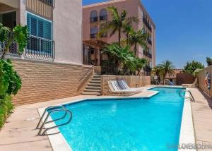 a swimming pool in front of a building at 2 bed 2 bath penthouse condo with AC and Ocean Views in San Diego