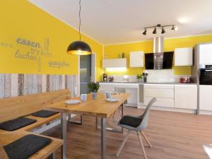 eine Küche und ein Esszimmer mit einem Holztisch und Stühlen in der Unterkunft Gezeiten App 1 Ostwind in Boltenhagen