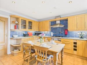 a kitchen with wooden cabinets and a table with chairs at Spacious 3-Bed Home in North Cornwall | Walk to Wadebridge | Near Camel Trail, Padstow & Rock | Free Parking in Wadebridge +41 photos