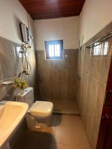 Un baño con inodoro, lavabo y ducha. en Hotel Halona, en Kandy 10 fotos más