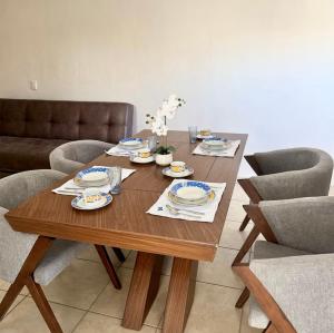 a wooden table with plates and dishes on it at JUCAR Place in Villa Hidalgo