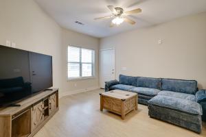 a living room with a couch and a flat screen tv at Pool Access, 1 Mi to Shops and Eats Crowley Rental in Crowley