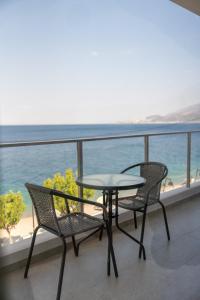 a table and chairs on a balcony with the ocean at Blue Krathis - Luxury Seafront apartments in Paralía Akrátas +23 photos