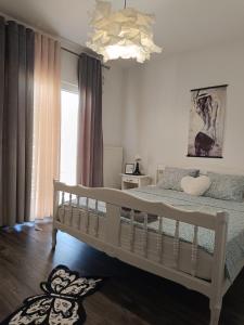 a bedroom with a white bed and a chandelier at Black and White Apartment - 2 bedrooms, walk to the beach in Duće