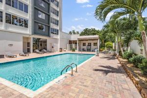 a swimming pool with palm trees and a building at Holiday Inn Tampa Westshore - Airport Area by IHG in Tampa