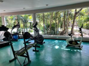 Un gimnasio con cintas de correr y bicicletas estáticas en una habitación. en La Escondida 34, en Playa del Carmen