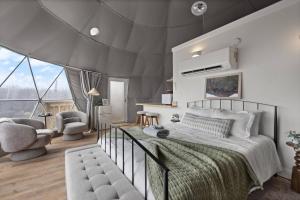 ein Schlafzimmer mit einem großen Bett und einem Stuhl in der Unterkunft "Bluegrass Bluff" - The Overlook LUX Dome - RRG in Stanton