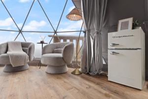 ein Wohnzimmer mit 2 Stühlen und einem Kühlschrank in der Unterkunft "Bluegrass Bluff" - The Overlook LUX Dome - RRG in Stanton
