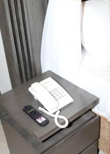 a phone and a remote control on a table at Ritro Plaza Hotel in Kampala +7 photos