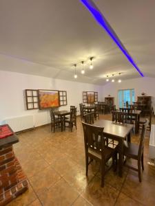 a dining room with wooden tables and chairs at Casa Corbeanu Transfagarasan in Bucşeneşti