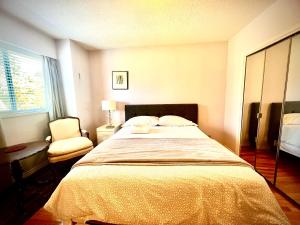 バンクーバーにあるSpacious place Close to UBC -1の大きなベッドと椅子のある寝室