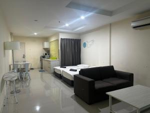 a room with a bed and a couch and a table at Homestay Marina in Lumut