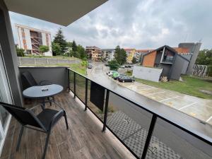 a balcony with a table and chairs and a street at Mića Apartment in Veliko Gradište