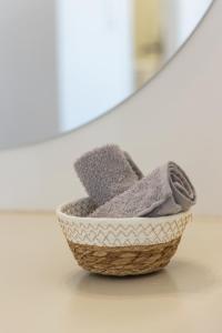 a basket of towels sitting on a floor at Aphrodite's Child Milos Maisonette in Adamantas +51 photos