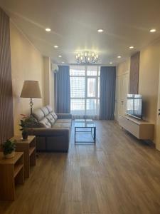 a living room with a couch and a television at Batumi Sea Apartment in Batumi