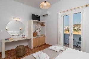 a bedroom with a bed and a desk and a mirror at Aphrodite's Child Milos Maisonette in Adamantas
