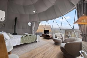 a bedroom with a bed and two chairs and a tv at "Pineview Peak" The Overlook LUX Dome - RRG in Stanton