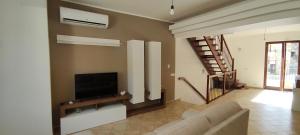 a living room with a couch and a flat screen tv at Tra mare e collina in Condrò